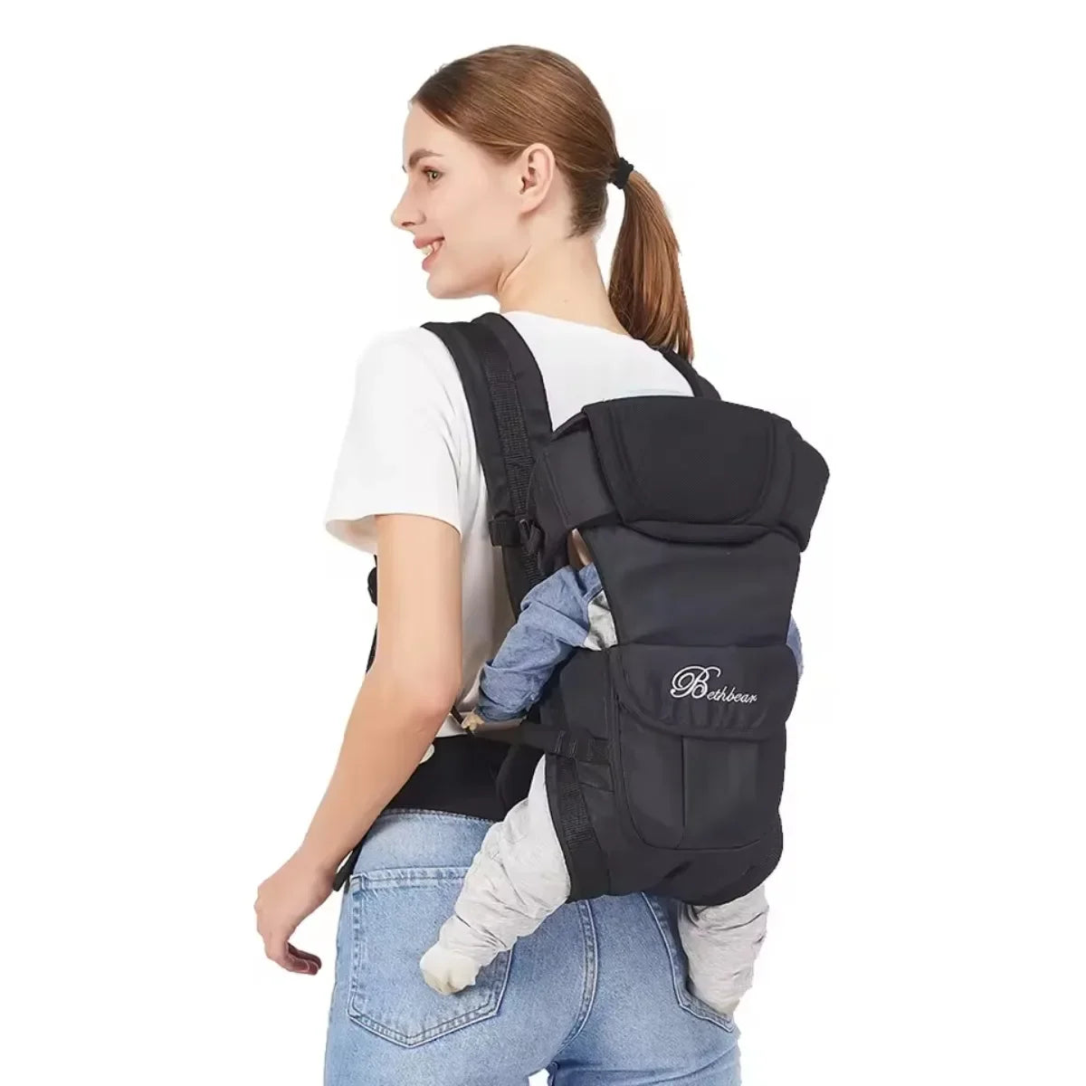 A woman in a white t-shirt carries a baby in a black baby carrier, showcasing a practical and secure holding style.